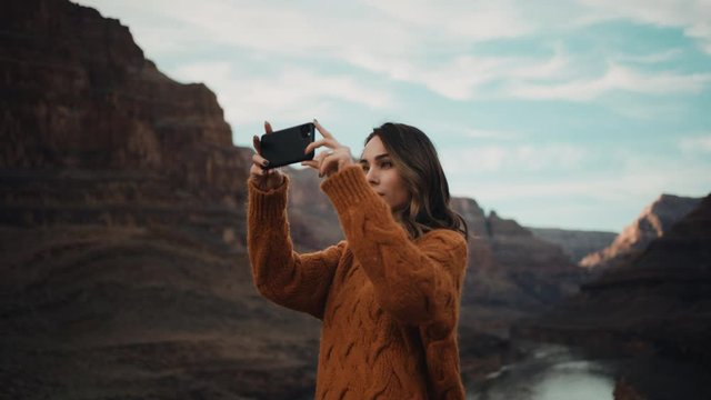 Traveler takes pictures of Grand Canyon in Arizona, river between mountains, famous natural landmark, traveling around the United States 