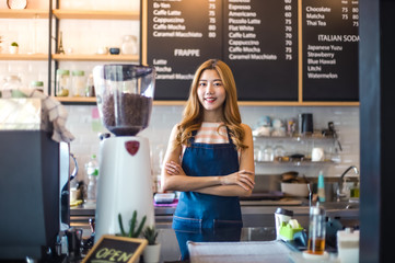Portrait young Asian woman barista feeling happy smiling at urban cafe. Small business owner Korean girl in apron relax toothy smile