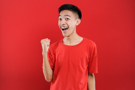 Young Asian teenager doing winning gesture, Happy get special gift