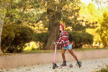 Young woman with kick scooter outdoors
