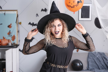 Beautiful woman dressed as witch for Halloween at home