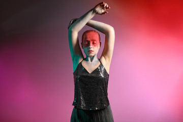 Beautiful woman with unusual makeup on color background