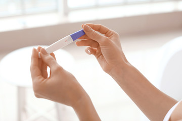 Obraz na płótnie Canvas Young woman with pregnancy test in bathroom, closeup