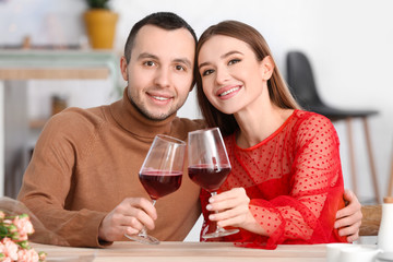 Happy young couple drinking wine on romantic date in cafe