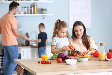 Obraz na płótnie Canvas Mother with daughter cooking together in kitchen