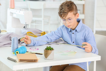 Cute little tailor working in atelier