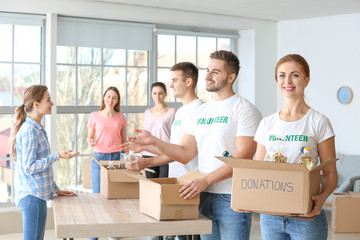 Team of volunteers giving products to poor people