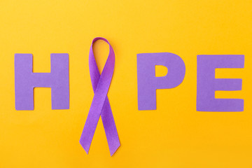 Violet ribbon and word HOPE on color background. Domestic violence concept