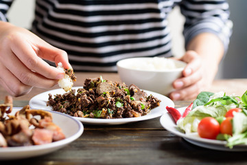 Northern Thai food, spicy minced pork salad (Larb Moo Kua) eating with sticky rice by hand