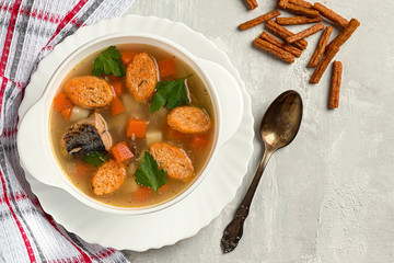 Fish soup with potatoes and carrots, on a concrete background with greens and crackers