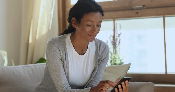Smiling millennial mixed race woman chatting with friends online.