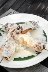 fish skewers with creamy coconut sauce and rice in vietnam