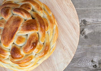 Edible bread basket. Top view. Yeast bread is woven and braided to resemble a basket. Swiss recipe Zopf, Butterzopf or Challah bread. Bread is placed on round wood cutting board.