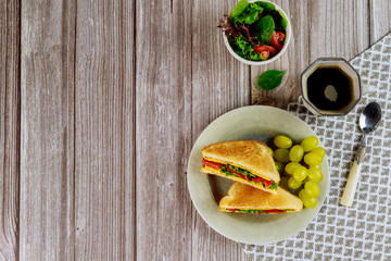 Healty grilled cheese sandwich with grape and cup of coffee.