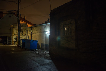 Fototapeta na wymiar Dark and eerie urban city alley at night in the winter