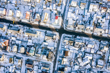 residential suburb area with houses covered with snow. aerial top down view