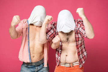 Two stupid men, for the sake of a joke, covered their heads with their tee-shirts, compared their...