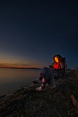 Woman in chair on the beach in the evening, Parksville, British Columbia