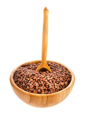 Wooden bowl of brown lentils with spoon isolated on a white background.