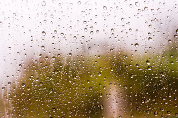 Textures of water droplets of rain flow down the windowpane. Rain drop on the car glass background, Blurred photo, Soft focus