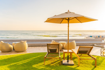 Umbrella and chair around beach sea ocean at sunset or sunrise time