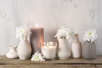 White flowers in neutral colored vases and candles