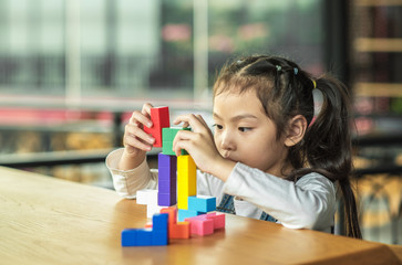 kid girl playing toy blocks. Concept of child meditation