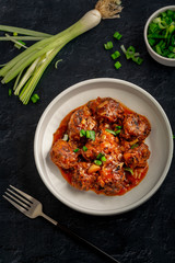 Vegetable manchurian served in a plate with soya sauce and spring onion