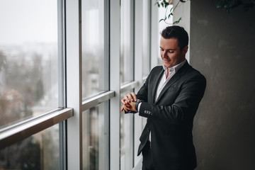 Successful and rich man looks in at the clock.