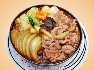 Bowl of Japanese-Style Beef Soup with Onions and Mushrooms Isolated on Orange Background