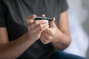 Biracial woman check sugar blood level with glucometer