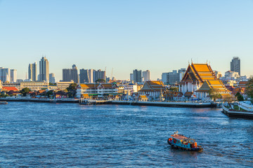 Naklejka premium In Bangkok with Chao Phraya River, Thai temple and Skyscraper in Bangkok city, Thailand.