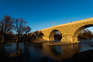 Fototapeta na wymiar Stone bridge with in Regensburg in afternoon light on sunny day