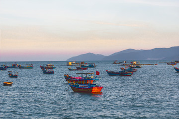 Evening sunset. View, landscape of sea and mountains, Vietnamese fishing boats.