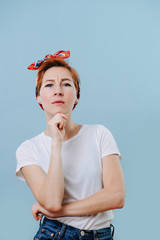 Portrait of serious housewife with short ginger hair making thinking gesture