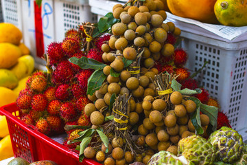 exotic fruits in Asia on the market Nephelium lappaceum, Rambutan (Ngo) and round Dimocarpus...