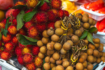 exotic fruits in Asia on the market Nephelium lappaceum, Rambutan (Ngo) and round Dimocarpus...