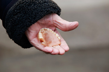 False teeth in old hands