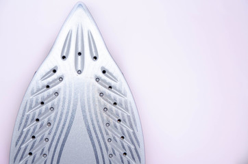 The iron is upright. modern with steam, steam boost, ceramic teflon sole on a white background.  Macro