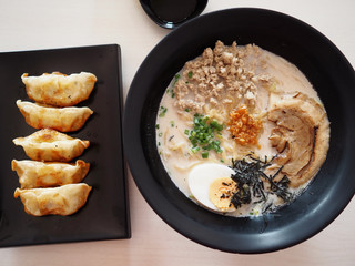 Tonkotsu ramen topping with Chaashu , Nori , Negi, tamago eat with Gyoza and ice cold green tea