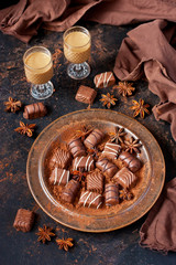 Composition with chocolate сandies and little glass with sweet  liqueur
