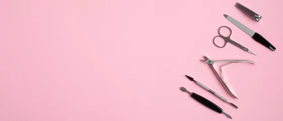 Fotobehang Manicure en pedicure tools op roze achtergrond. Bovenaanzicht met kopie ruimte. Nagel salon banner ontwerpsjabloon. Schoonheidsbehandeling en handverzorgingsconcept © photoguns