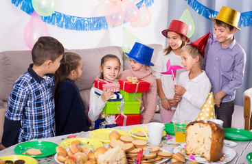 Friendly children presenting gifts to girl birthday