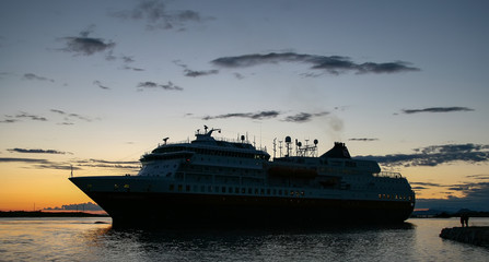 Fototapeta na wymiar The coast passenger ships arrive at Brønnøysund harbor in the midnight sun, Nordland county 