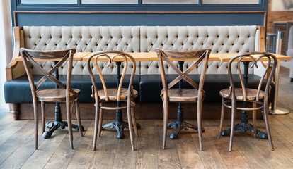 Row of vintage chairs with wooden table and stylish sofa in the cozy coffee room.