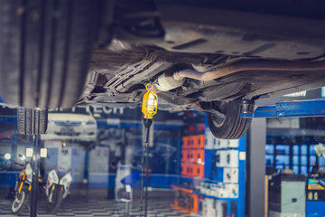 Car lifting on a hoist in the auto service company for fixing and replacing spare parts concepts