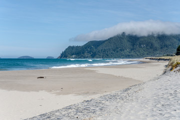 ocean waves on empty sand shore, Pauanui, New Zealand