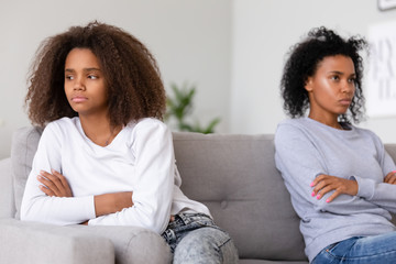 Stubborn african american teen daughter ignoring angry annoyed mom