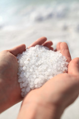 Fototapeta na wymiar Close-up of the salt from the Death Sea in Jordan in woman<s hands .