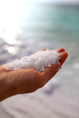 Fototapeta na wymiar Close-up of the salt from the Death Sea in Jordan in woman<s hands .